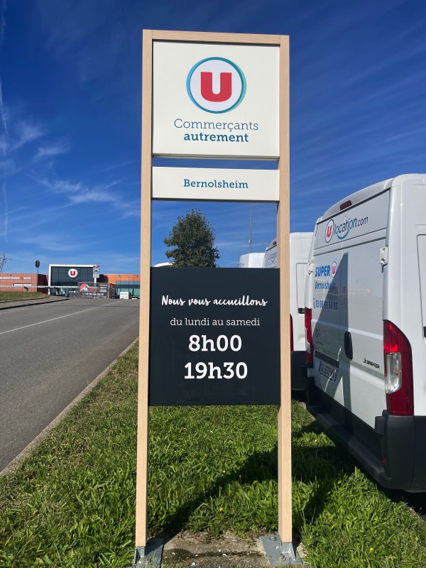 Impression de nouveaux Horaires sur totem signalétique à l’entrée du Parking Super U Bernolsheim Proche Brumath